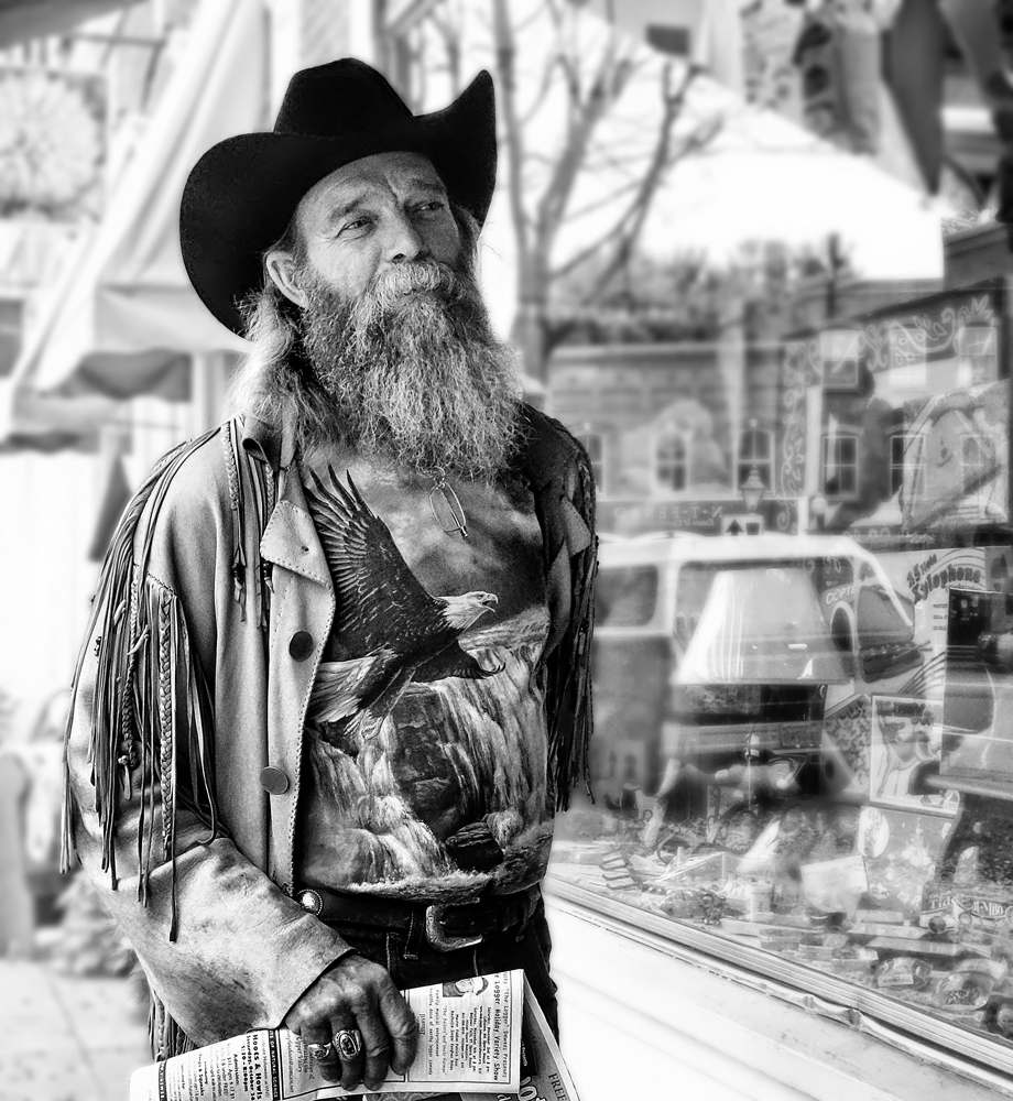 Street photography, bearded man, cowboy hat, shopping, jacket with fringes, shop window, newspaper, Woodstock, VT