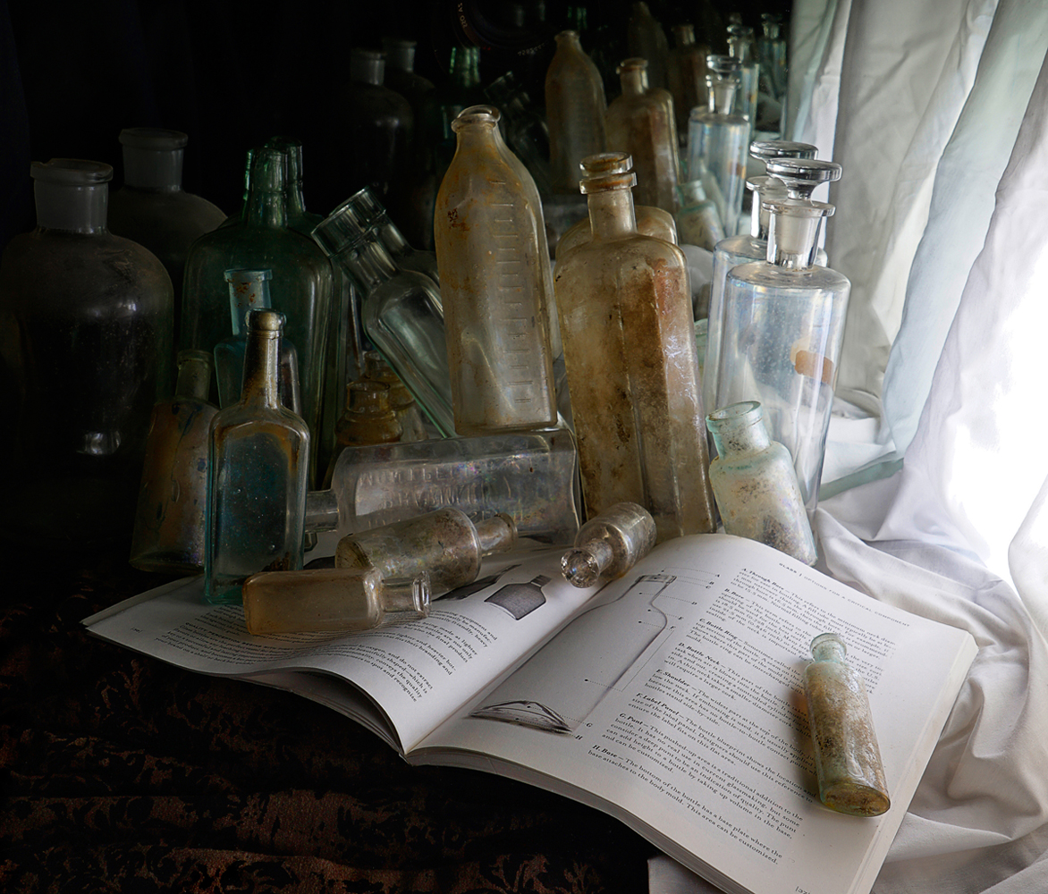 Still life, antique bottles, old glass bottle, book