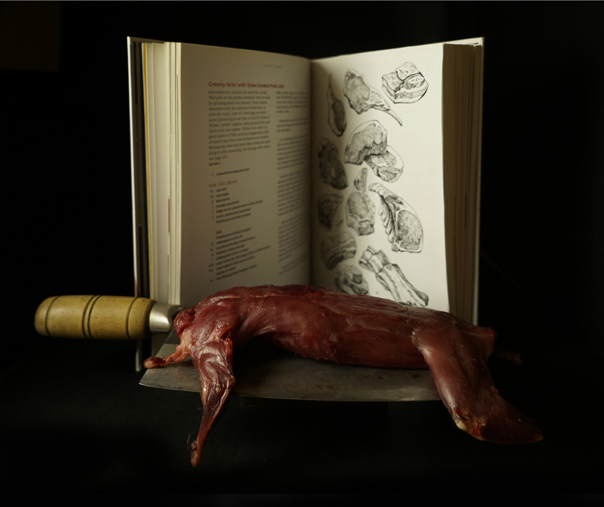 Food still life, small game carcass, book, meat cleaver